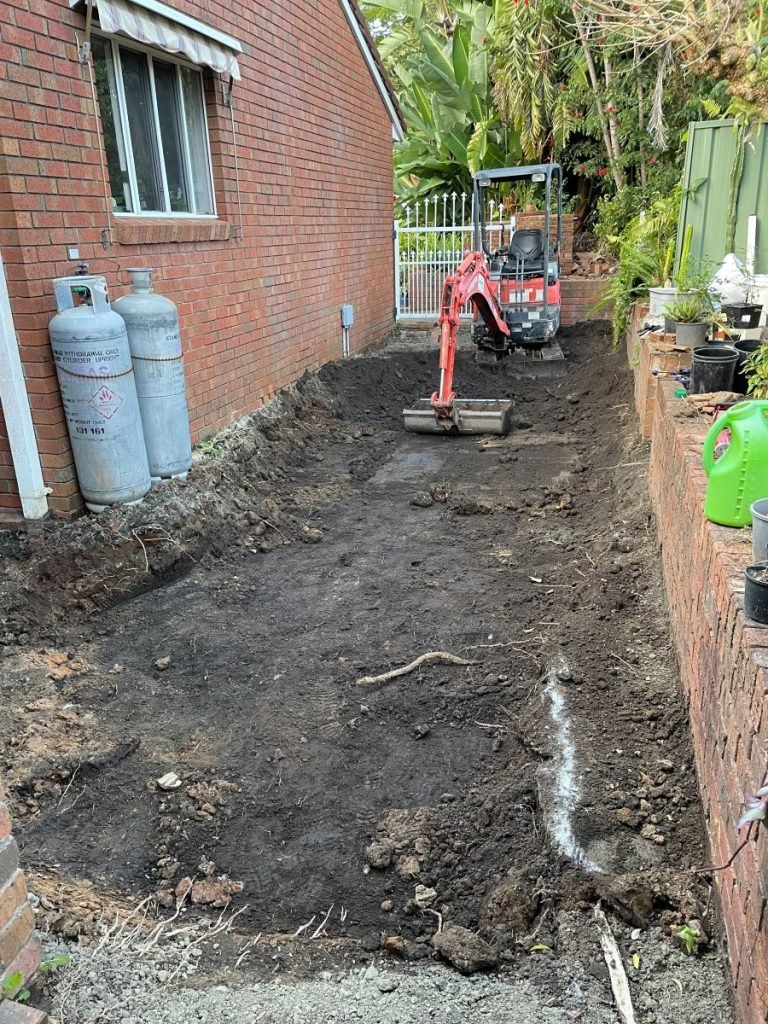 Toormina Coffs Harbour Excavator Hire. Lowering paver area to prevent water flowing under the house
